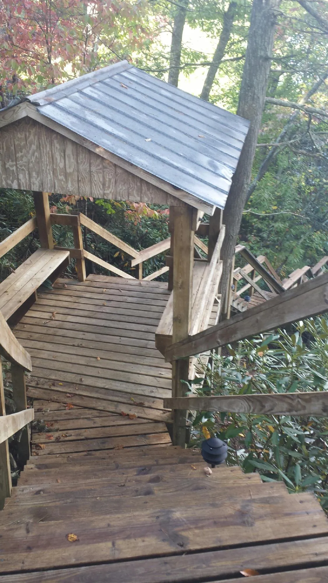Metal roofed shelter over wooden steps on a wooded walkway — Skylight Repair & Installation work by our crew in New Goshen