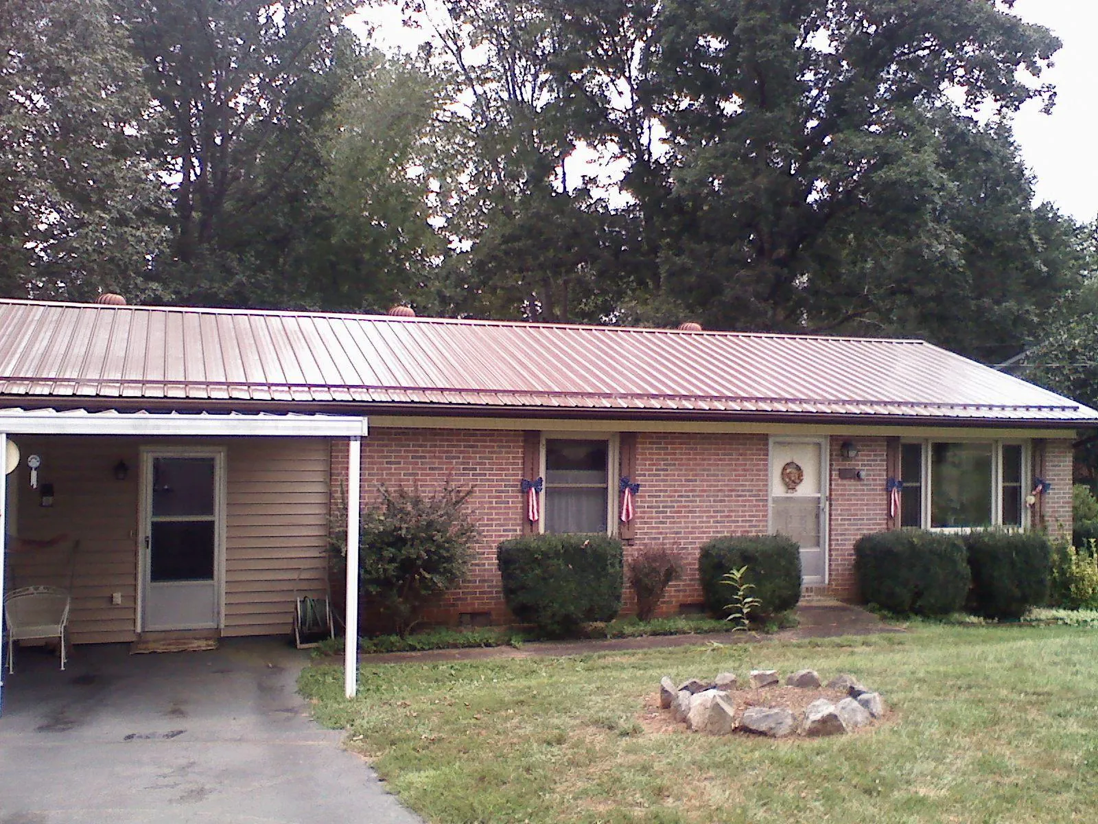 Bronze metal roof and carport on a brick ranch home — Roof Repair work by our crew in New Goshen